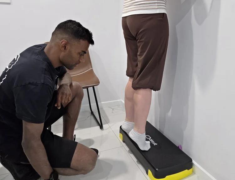 Ash observing a calf exercise on a step.