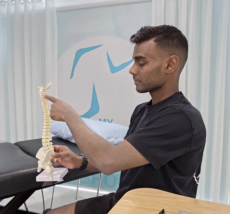 Ash explaining the spine using an anatomical model.