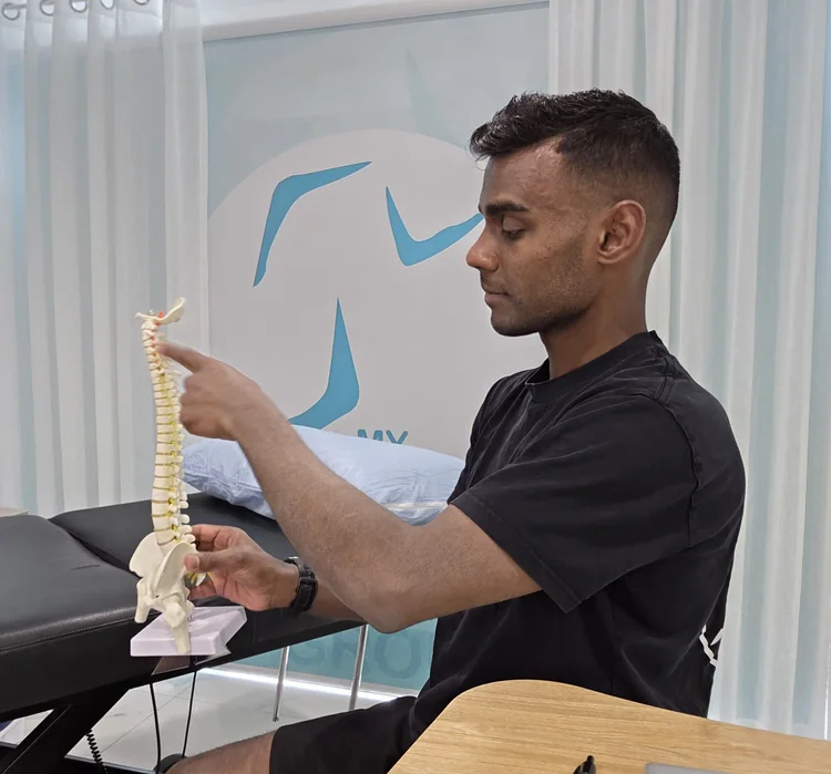 Ash explaining the spine using an anatomical model.